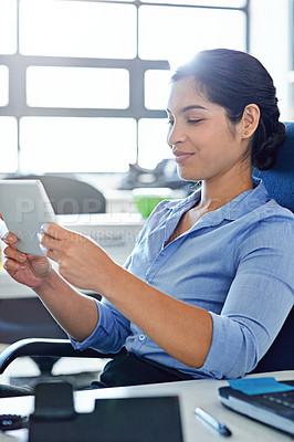 Buy stock photo Shot of a young businesswoman using a digital tablet at work