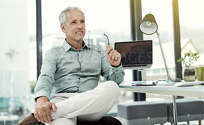 Buy stock photo Shot of a smiling mature businessman sitting at his desk in an office