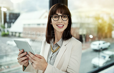 Buy stock photo Portrait of a young businesswoman using a digital tablet while standing in an office