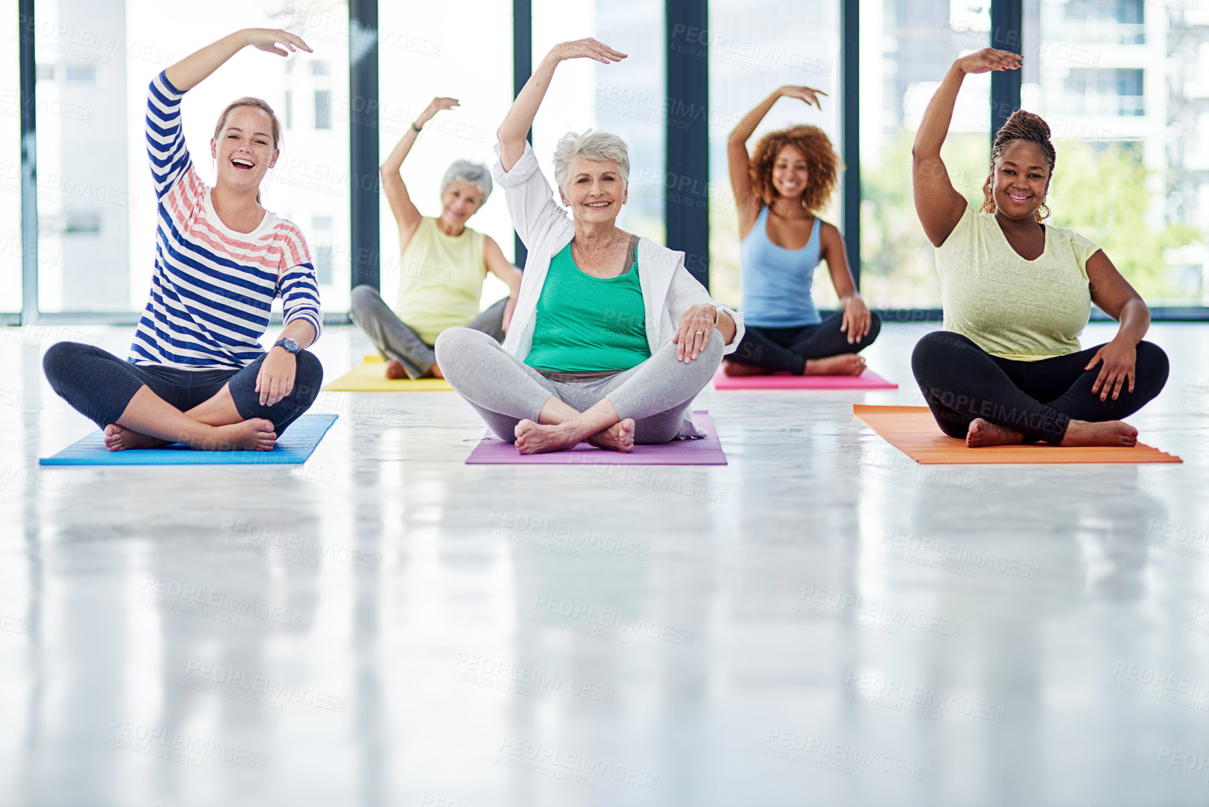 Buy stock photo Shot of a group of women doing yoga indoors