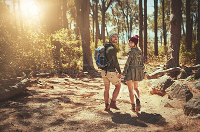 Buy stock photo Rearview shot of an affectionate young couple hiking