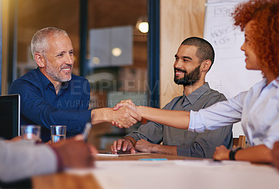Buy stock photo Shot of colleagues shaking hands in an office meeting