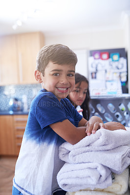 Buy stock photo Portrait, kid and laundry for cleaning in kitchen family home with teamwork, sister and helping together. Smile, linen and face of boy in house for chores with towels, cooperation and responsibility
