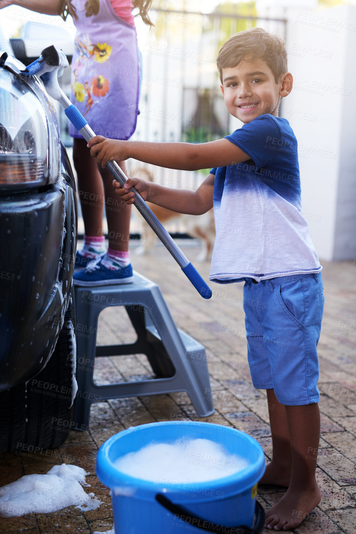 Buy stock photo Child, portrait and washing car in home or cleaning responsibility for chore, task or helping. Boy, smile and bubble soap on vehicle for dirty transport or independence teamwork, learning or youth