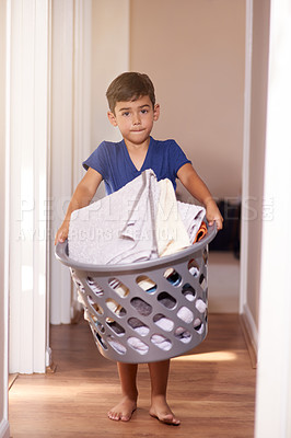 Buy stock photo Child, boy or laundry in home with portrait for cleaning, sad and punishment with routine or helping. Kid, clothes and washing basket for responsibility, learning or chores with independence in house
