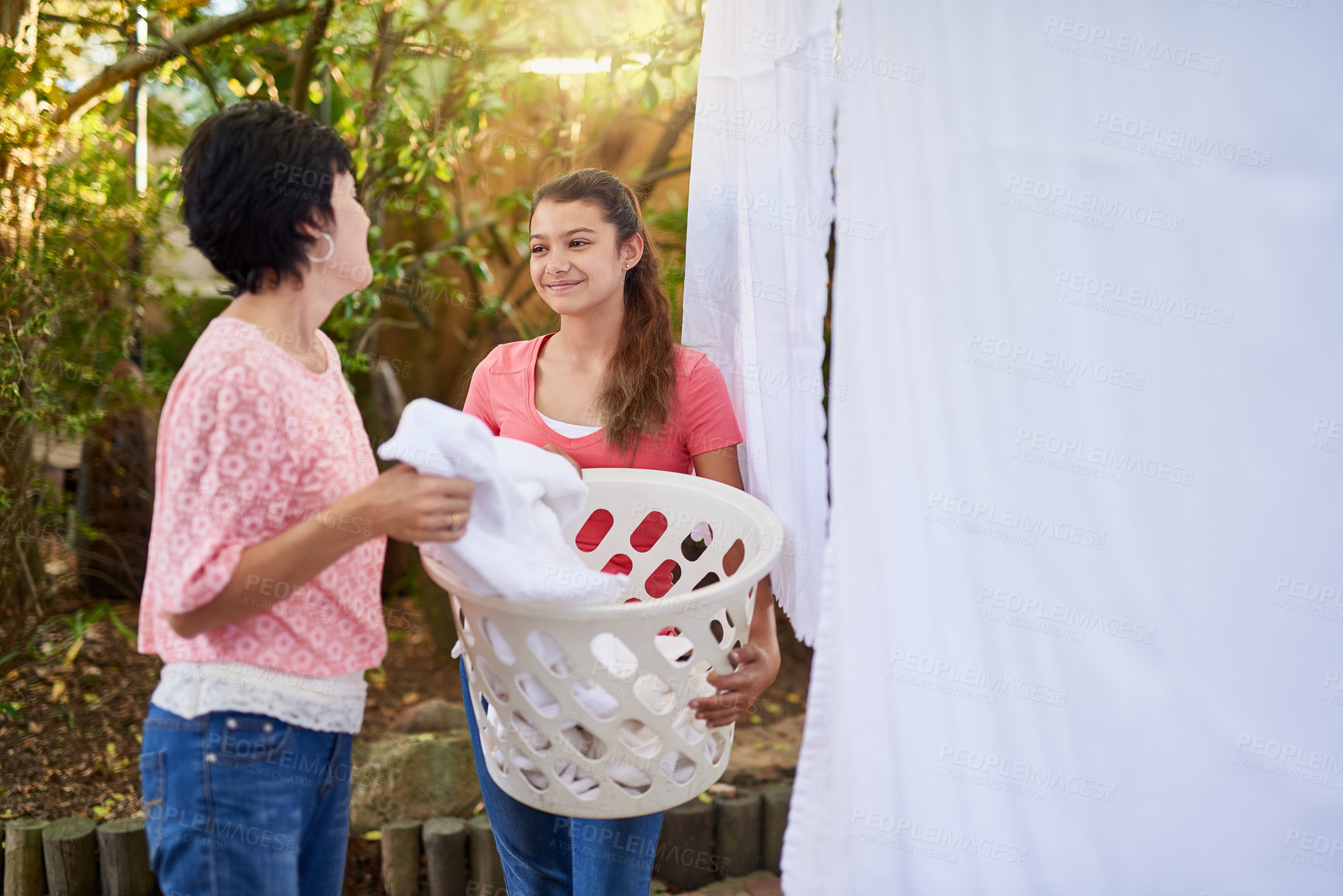 Buy stock photo Shot of a mother and daughter hanging up laundry together outside