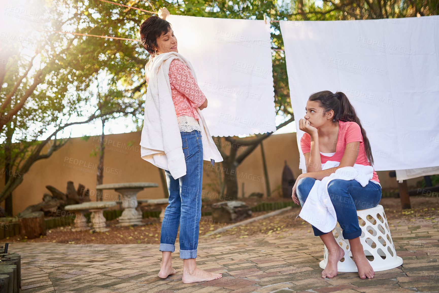 Buy stock photo Shot of a mother and daughter hanging up laundry together outside