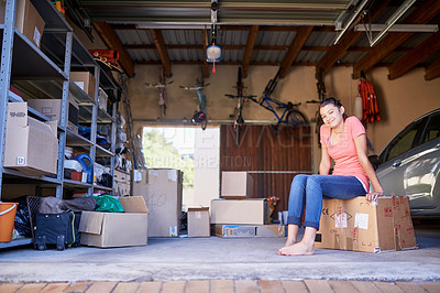 Buy stock photo Portrait of a young girl sitting on a box in a garage