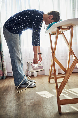 Buy stock photo Shot of a woman with her head down on a pile of clothes on an ironing board