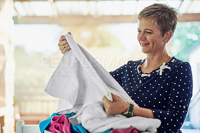 Buy stock photo Shot of a woman busy with some laundry