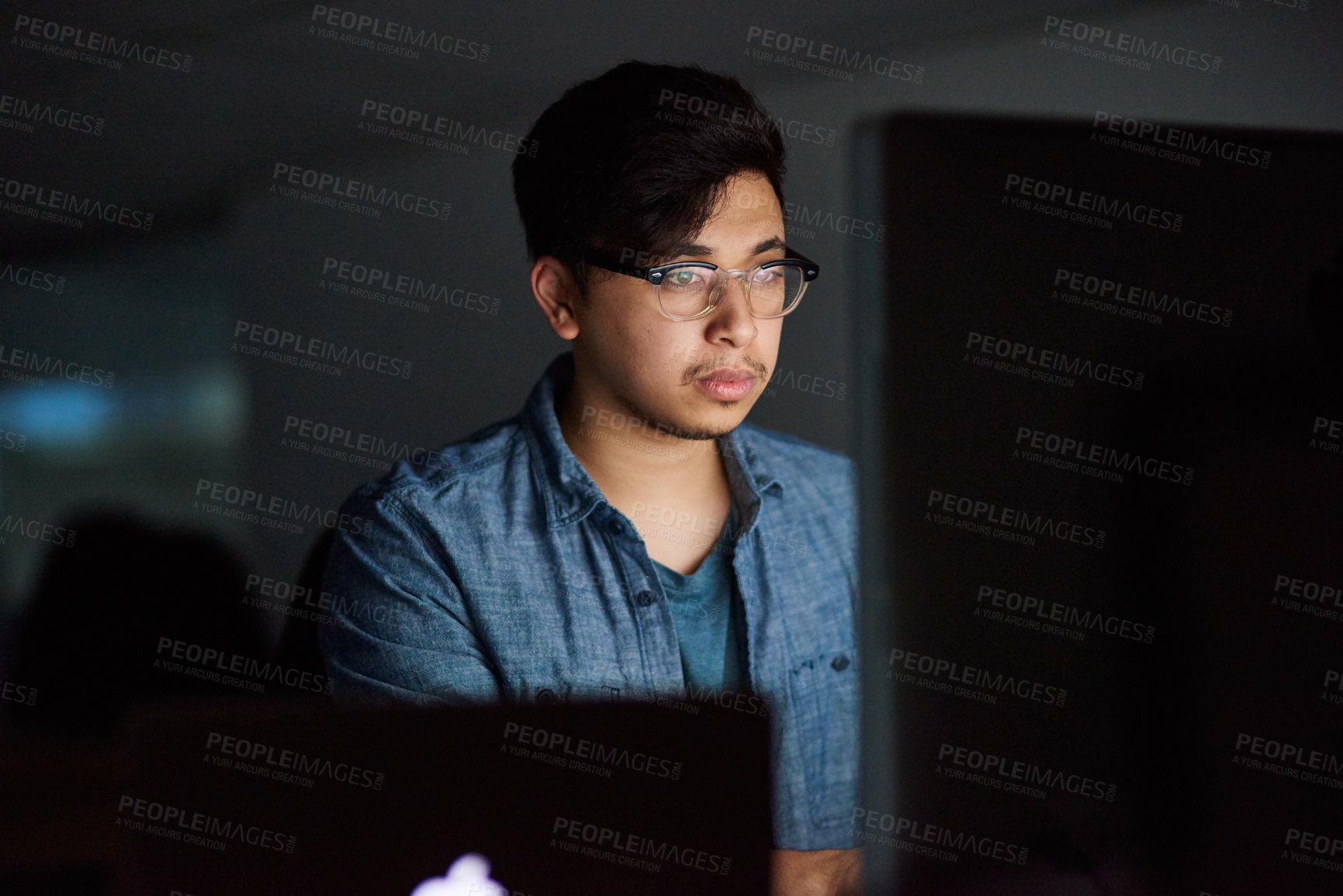 Buy stock photo Cropped shot of a young man working late in his office