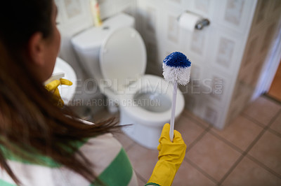 Buy stock photo Shot of a young woman holding a toilet brush in a bathroom