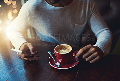 Buy stock photo Cropped shot of a young man using his cellphone in a coffee shop