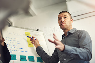 Buy stock photo Shot of a man giving a presentation to colleagues in an office