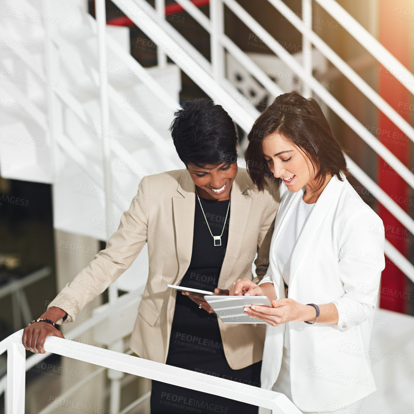 Buy stock photo Business, women and tablet on stairs in office for meeting agenda, client briefing and compare notes. Professional, teamwork and happy in company building with digital tech for creative brainstorming