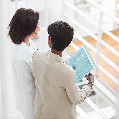 Buy stock photo Shot of two businesswomen standing in an office