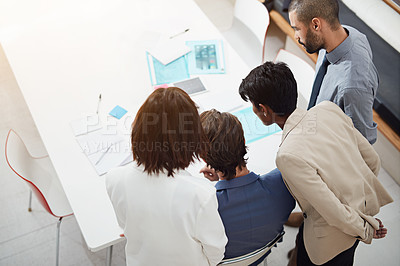 Buy stock photo Shot of businesspeople crowding around a digital tablet in an office meeting