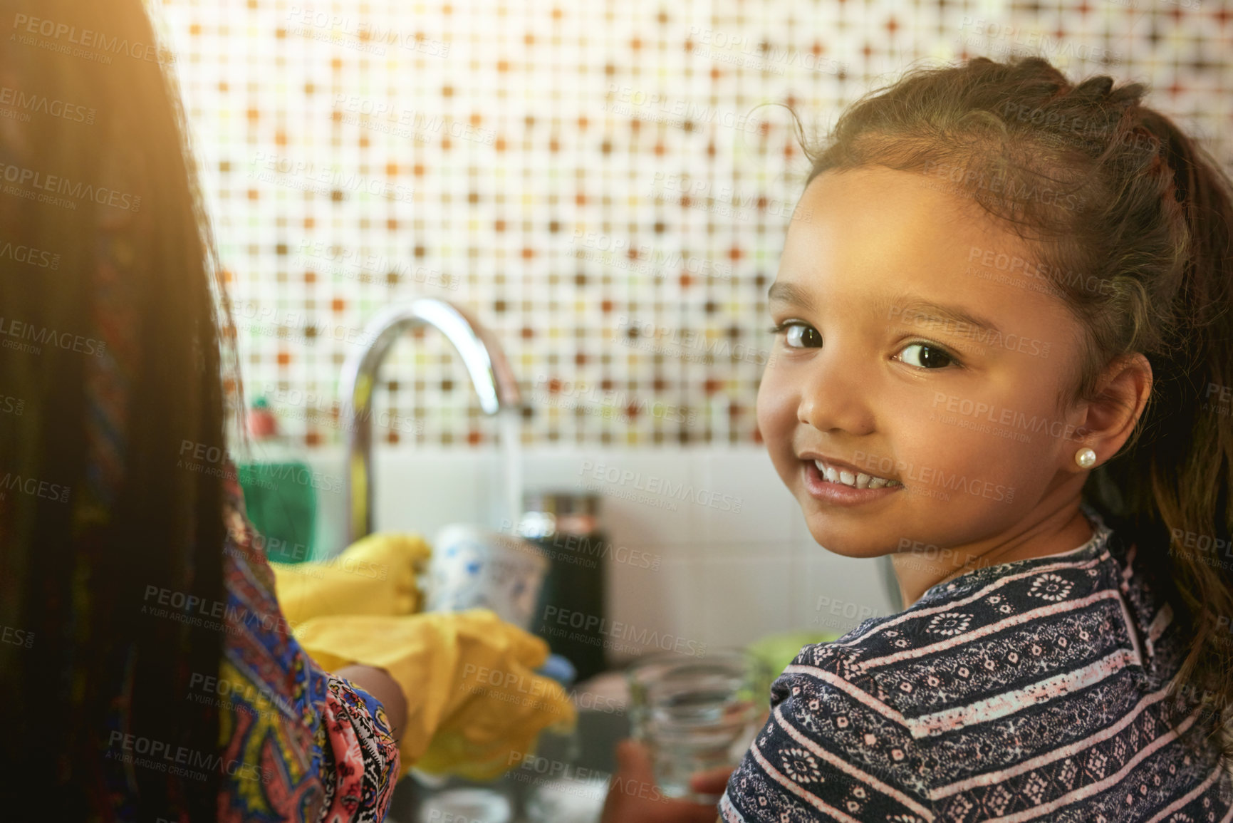 Buy stock photo Portrait of a young girl washing dishes in a kicthen