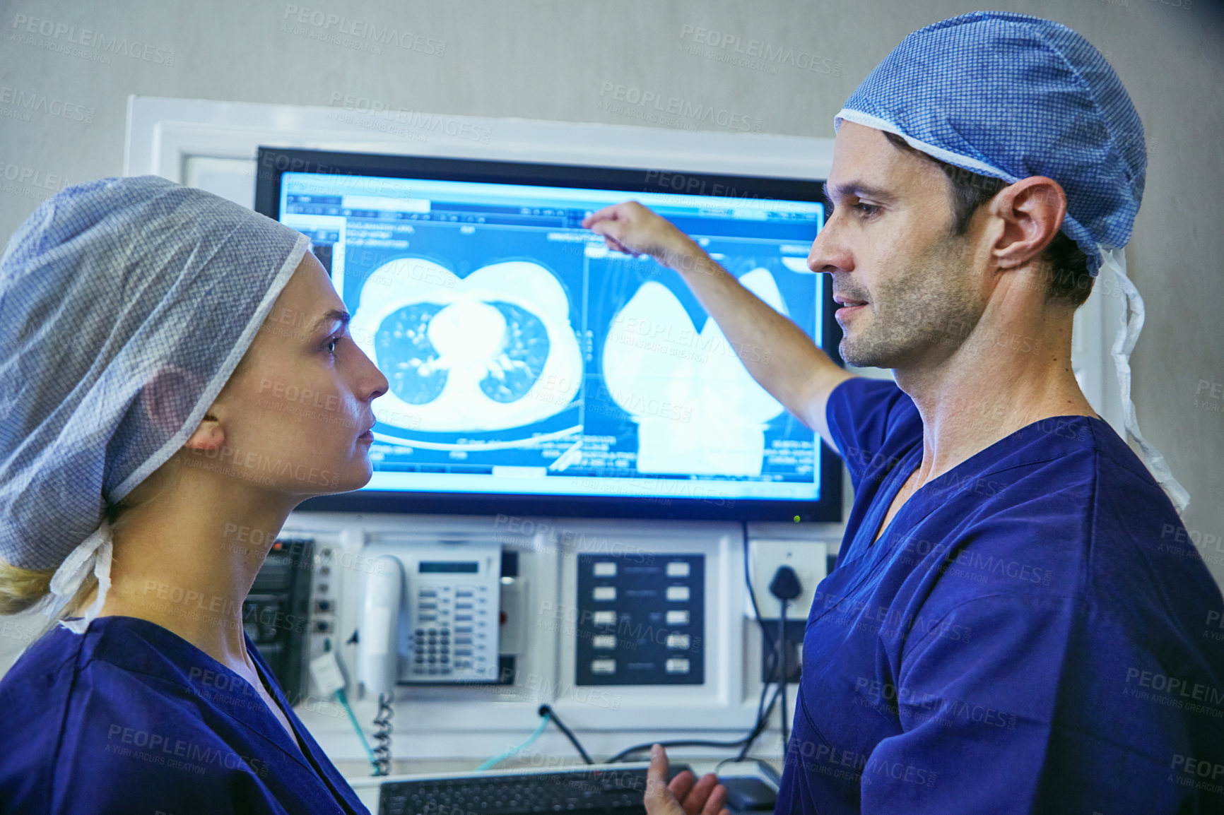 Buy stock photo Shot of a team of surgeons discussing a patient’s medical scans