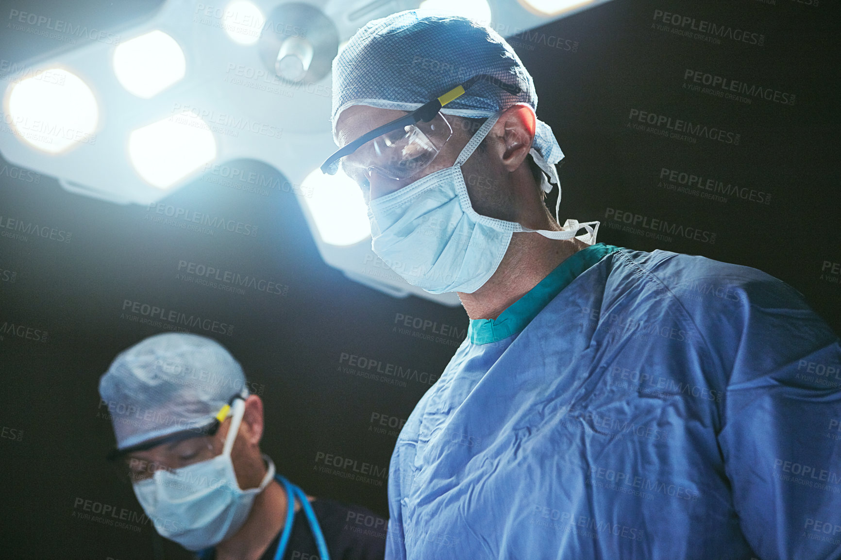 Buy stock photo Cropped shot of surgeons in an operating room