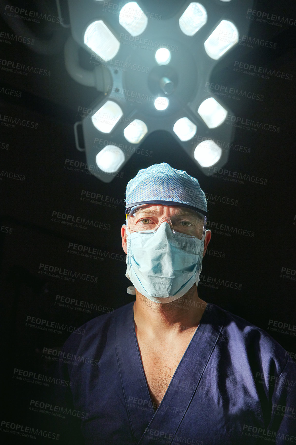 Buy stock photo Cropped portrait of a male doctor against a dark background