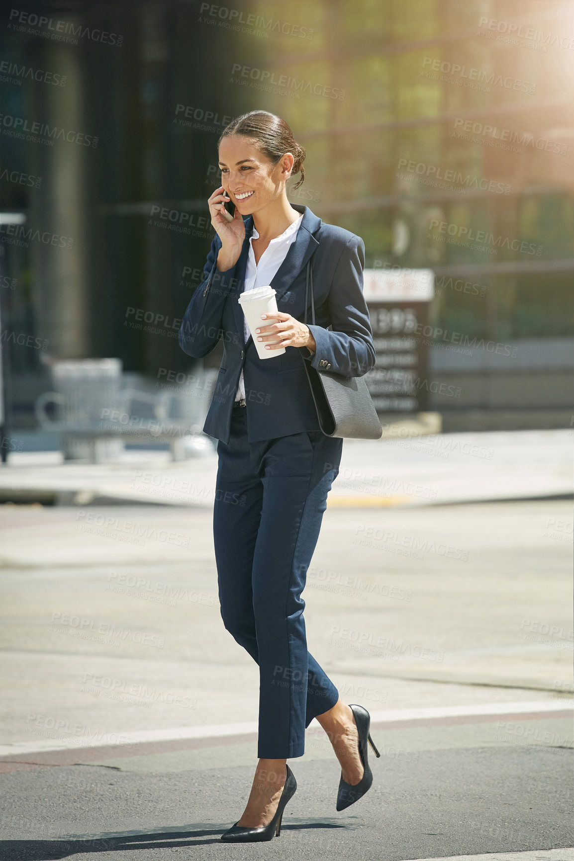 Buy stock photo Shot of a young businesswoman talking on her phone while out in the city