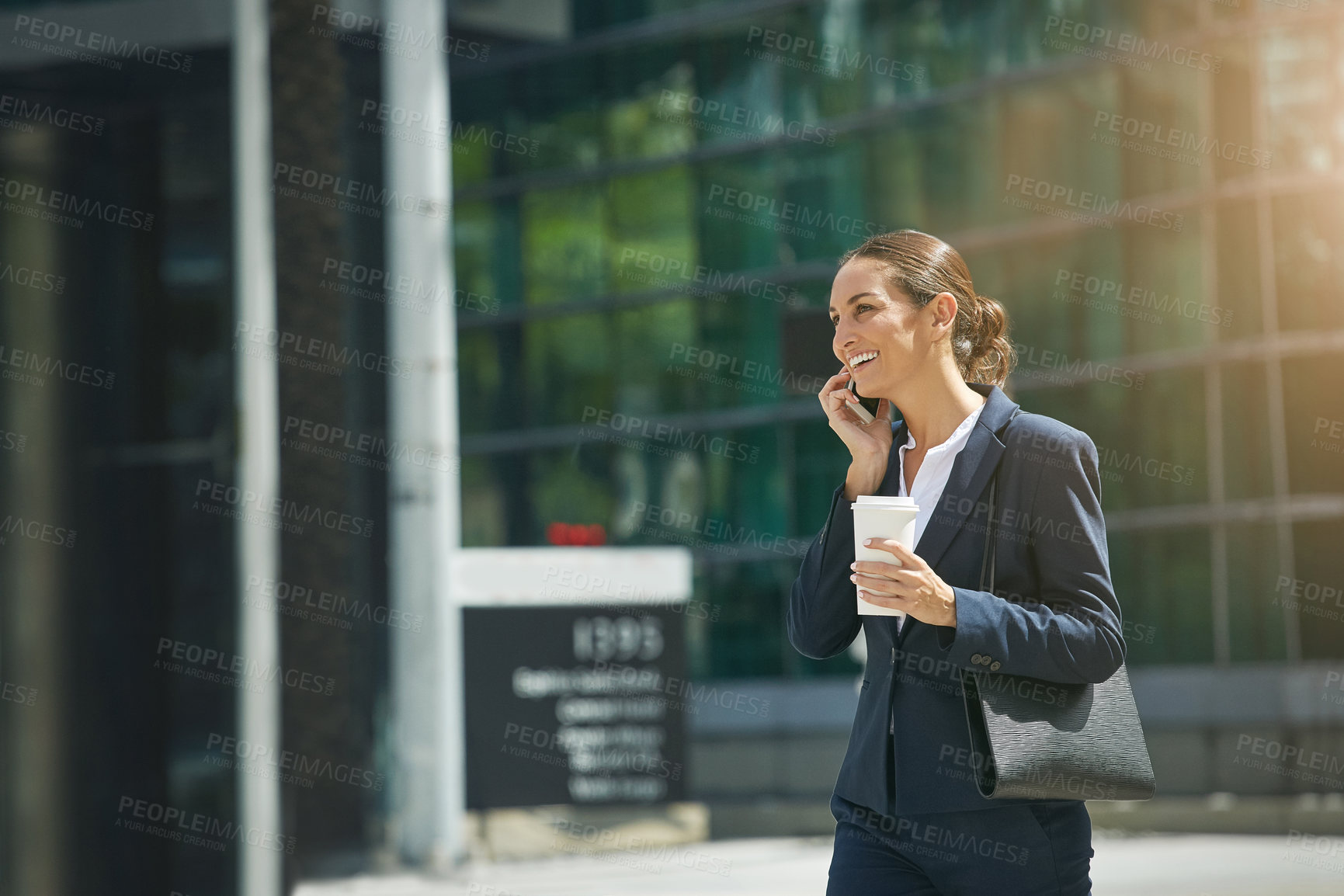 Buy stock photo Shot of a young businesswoman talking on her phone while out in the city