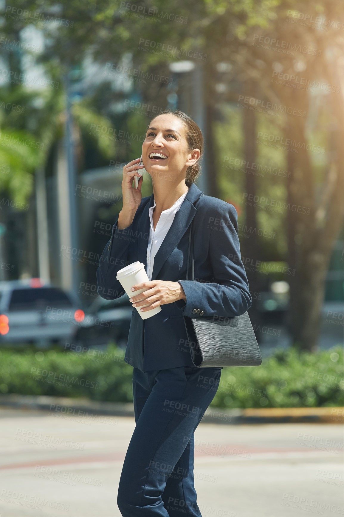 Buy stock photo Shot of a young businesswoman talking on her phone while out in the city