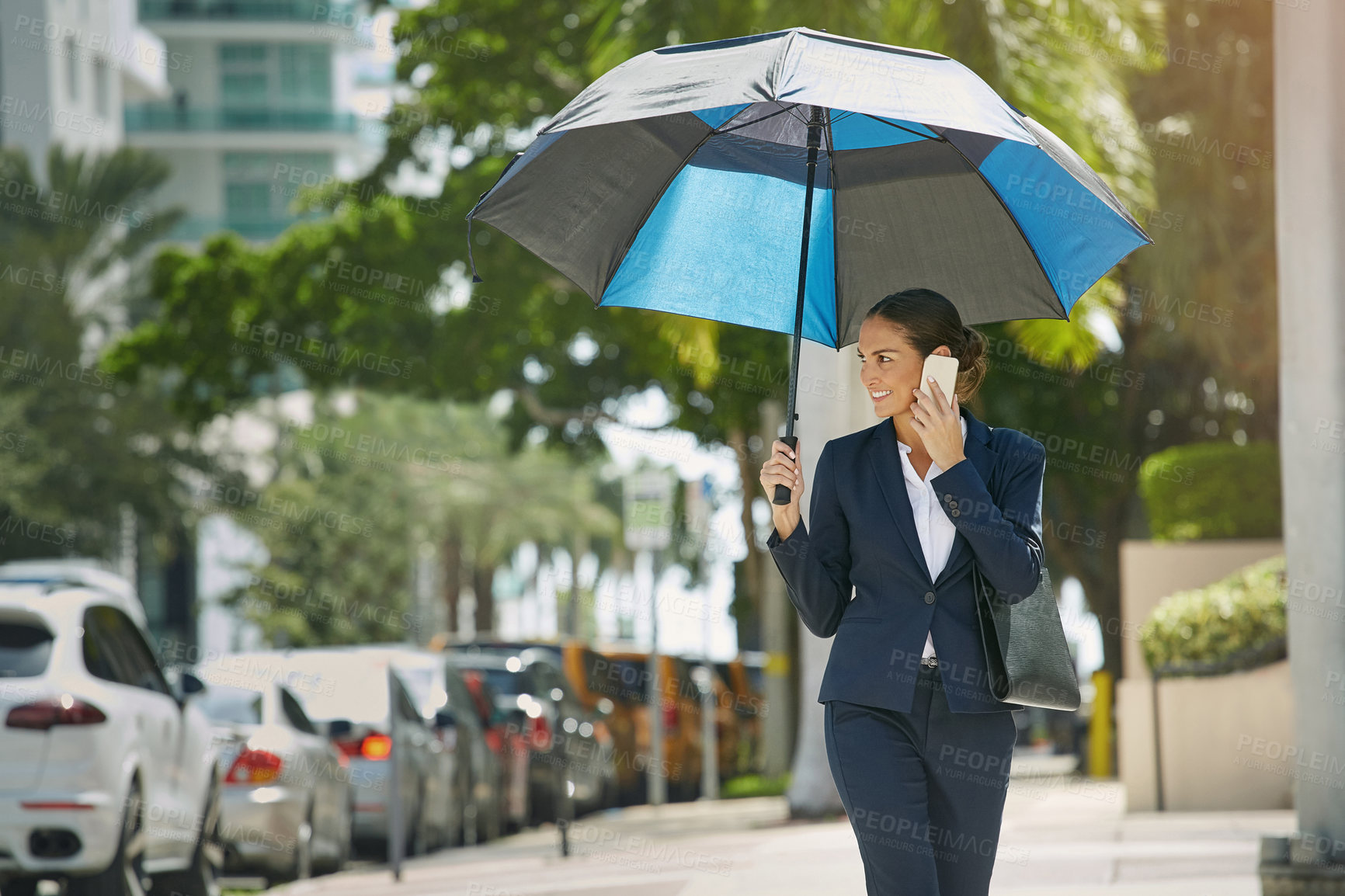 Buy stock photo Shot of a young businesswoman talking on her phone while out in the city