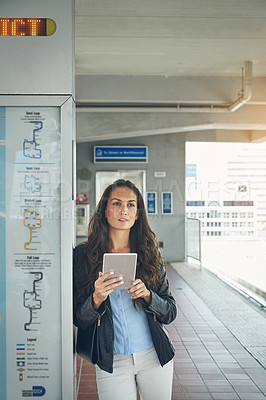 Buy stock photo Shot of a young woman using a digital tablet at a train station