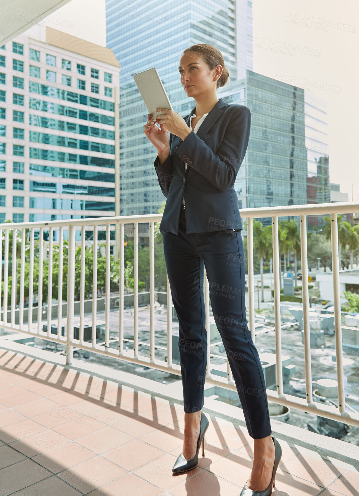 Buy stock photo Shot of a young businesswoman using a digital tablet on her way to the office