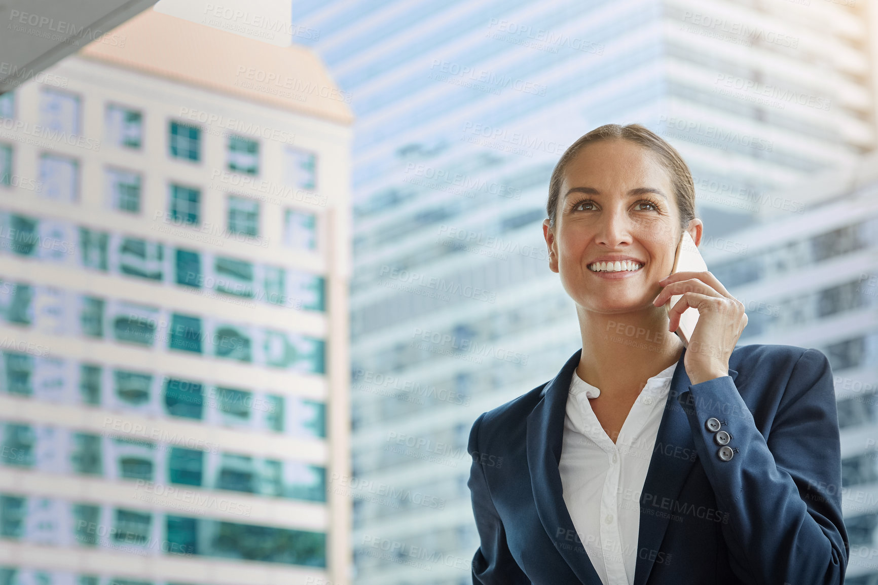 Buy stock photo Shot of a young businesswoman talking on her cellphone on the way to the office