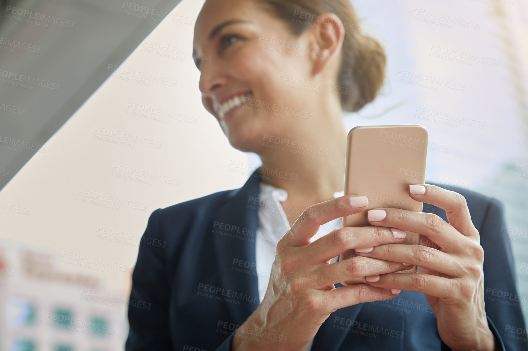 Buy stock photo Shot of a young businesswoman using a cellphone on the way to the office