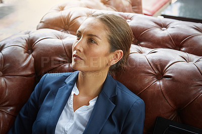 Buy stock photo Shot of a young businesswoman sitting on a sofa