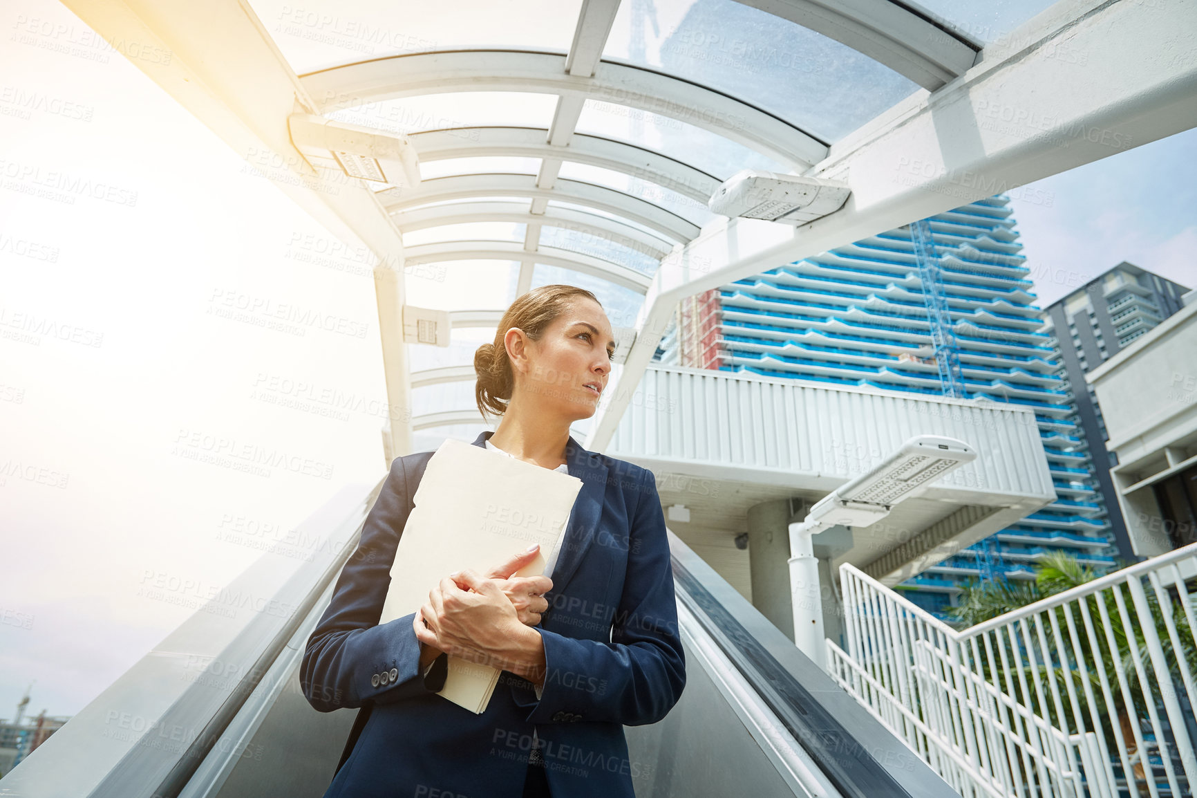 Buy stock photo Shot of a young businesswoman holding paperwork while on the way to the office