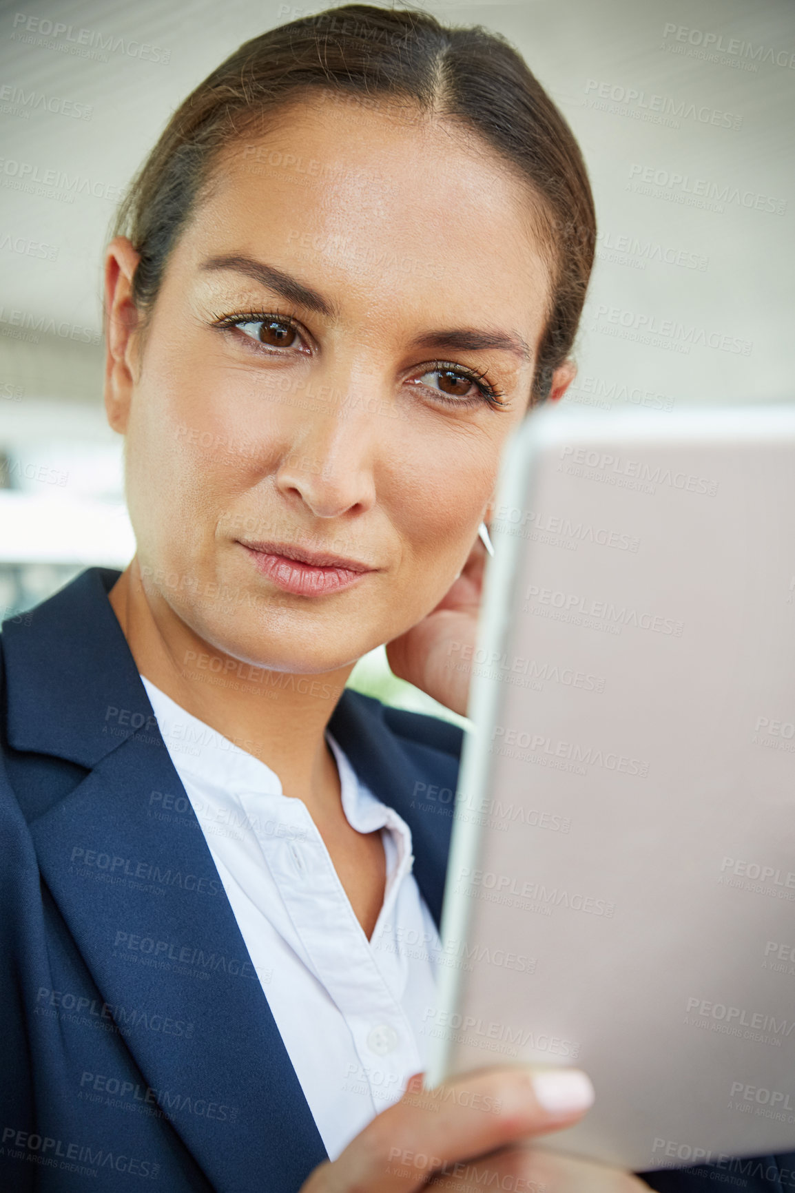 Buy stock photo Shot of a young businesswoman using a digital tablet outside