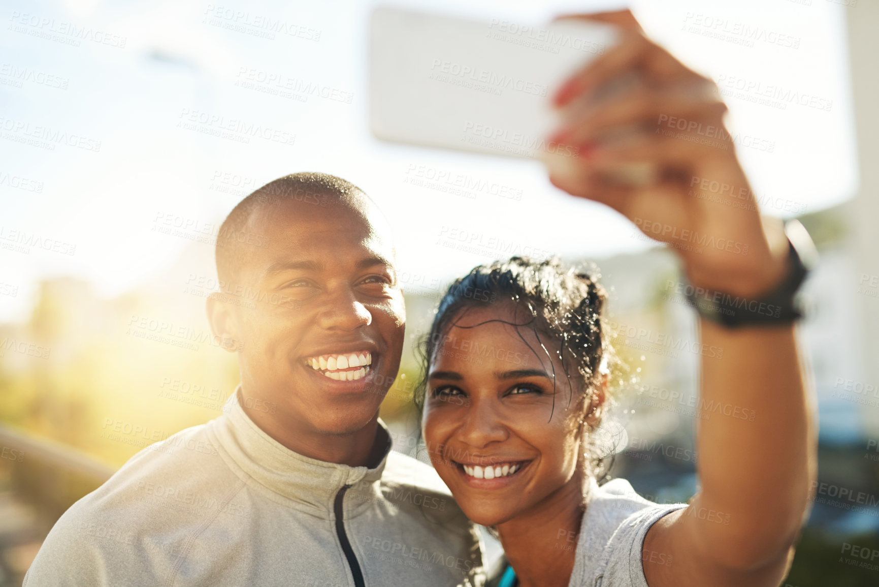 Buy stock photo Shot of a young sporty couple taking a photo together with a cellphone