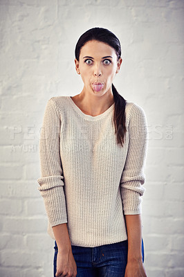 Buy stock photo Portrait of a young woman sticking out her tongue