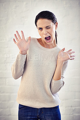 Buy stock photo Shot of a young woman with her hands in the air looking surprised