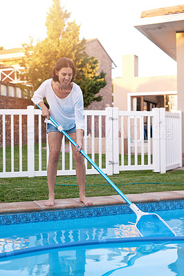 Buy stock photo Shot of a young woman cleaning a pool