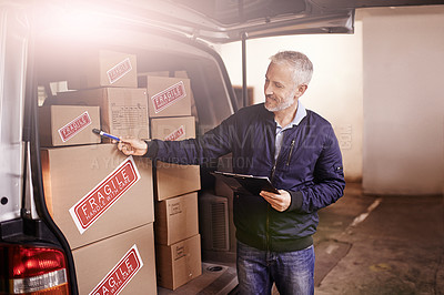 Buy stock photo Shot of a mature delivery man counting the boxes in his van