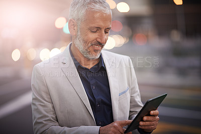 Buy stock photo Mature businessman, tablet and reading in city, happy or application for contact, deal or update in metro. Person, executive and check email on sidewalk with smile for notification on trip in Germany