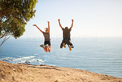 Buy stock photo Shot of a young couple jumping for joy after their workout