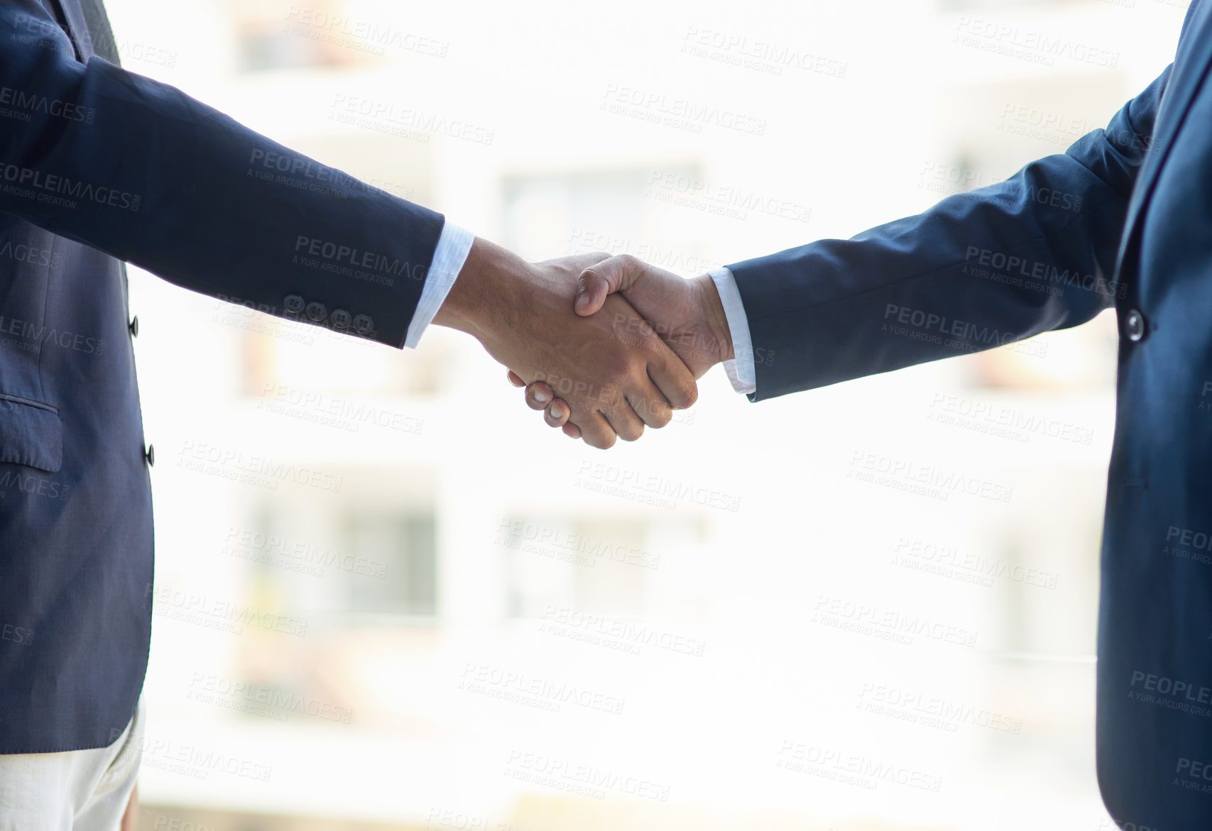 Buy stock photo Shot of two unidentifiable businessmen shaking hands in the office