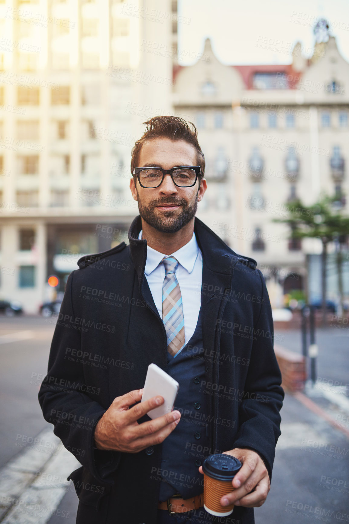 Buy stock photo Portrait of a stylish man with coffee and phone in hand while out in the city