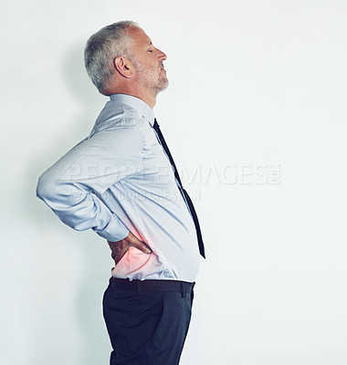 Buy stock photo Studio shot of a mature man experiencing back ache against a white background