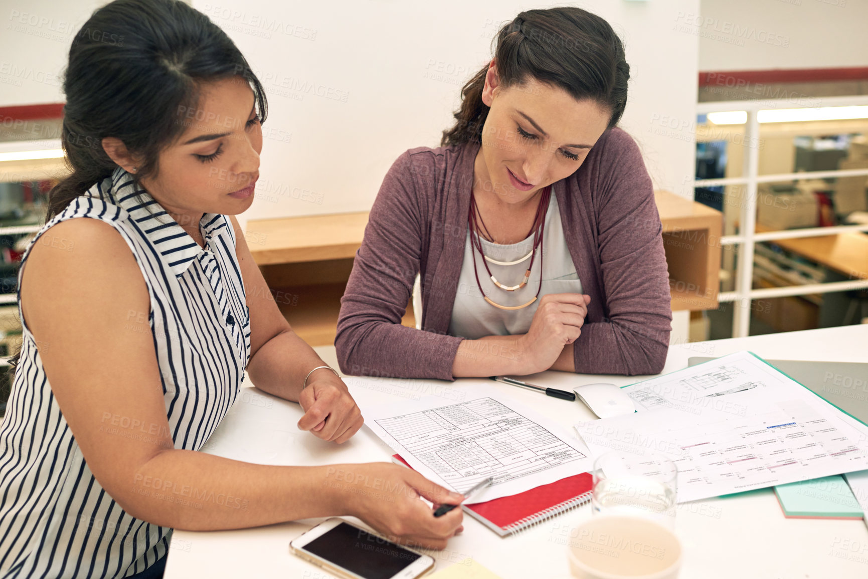 Buy stock photo Shot of a two colleagues having a meeting in a modern office