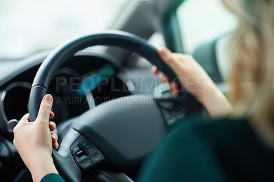 Buy stock photo Shot of a woman holding onto a steering wheel while driving