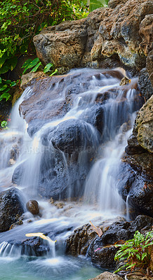 Buy stock photo Serene pond with a waterfall over rocks. Landscape of a small natural spring near a clear pool on a mountain trail. Relaxing peaceful nature scene. Calm background of water flowing on stone outside