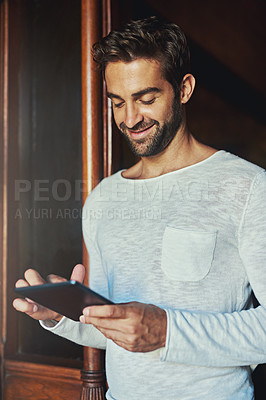 Buy stock photo Shot of a handsome man using a digital tablet